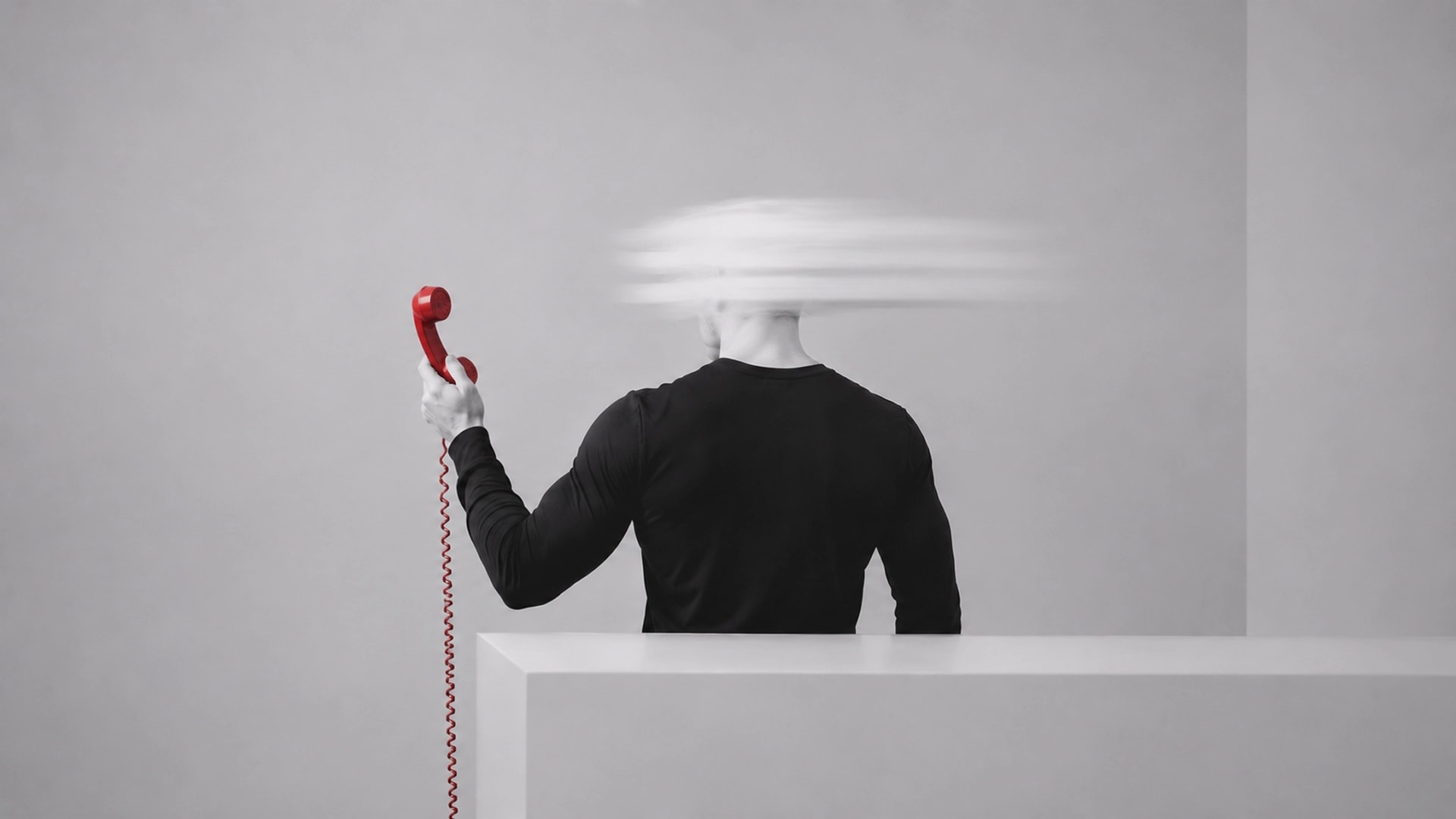 Man with blurred face holding red phone away from his body